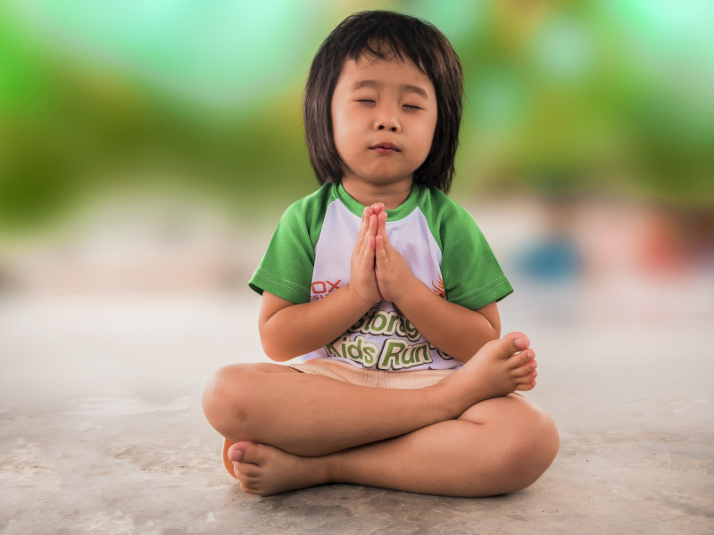 Niña meditando o haciendo yoga