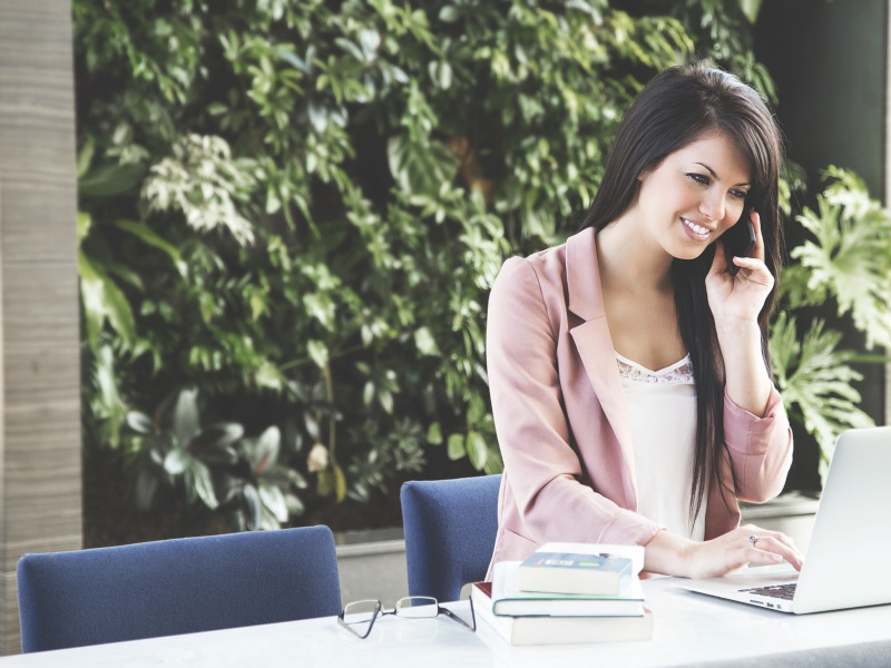 Mujer al teléfono con portátil