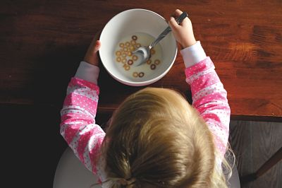 Aparece una niña pequeña comiendo cereales sola