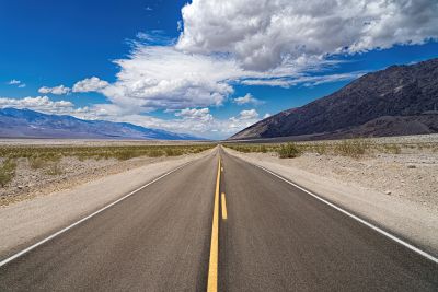 Carretera vacía con rayas amarillas en mitad del desierto.