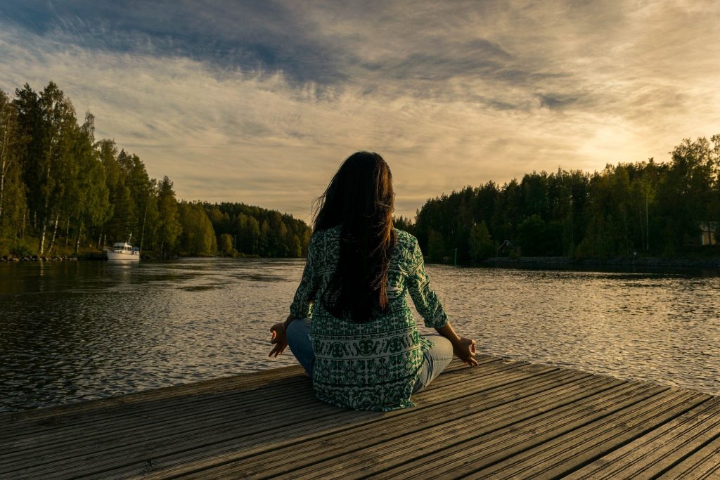 mujer haciendo relajación frente al lago